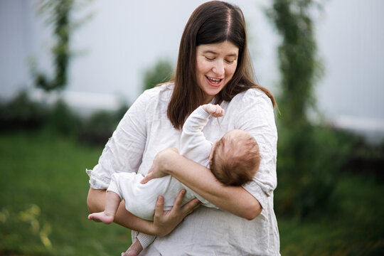 Happy Mothers day! Mother hugging cute newborn baby  in the garden. Love, care and family in countryside concept. Adoption and maternity