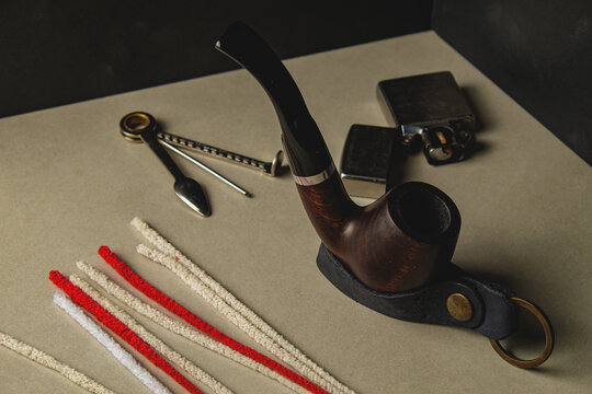 Artistic display of vintage smoking pipe and accessories on a creative backdrop