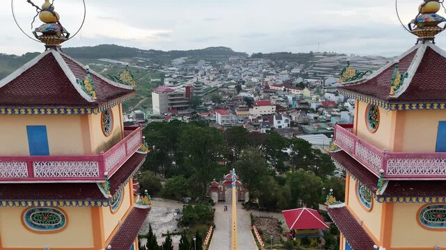 Aerial view of Cao Dai Temple towers and greenhouses on hills, Dalat, Vietnam.