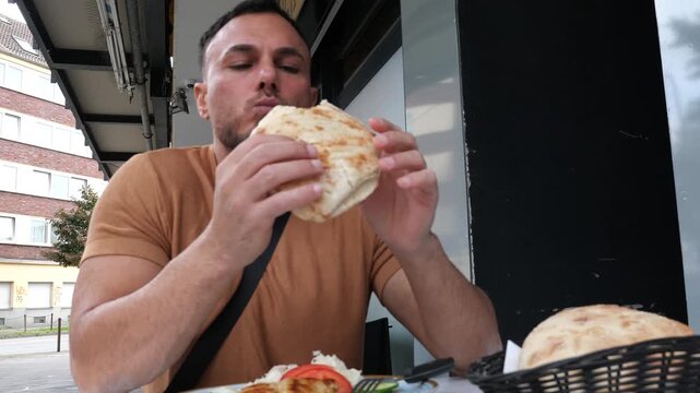 Handsome Man Eating Delicious Street Food Sandwich Outdoors in European City Close Up Enjoying Fast Food Meal Daytime Lifestyle Concept Real Estate