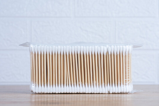 Pack of wooden cotton swabs in clear plastic bag on table. Personal hygiene, ear cleaning and beauty care product concept for daily use.