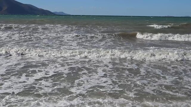 Waves on a murky and muddy sea during stormy weather. Turbid grey water and rough waves near the coastline. 