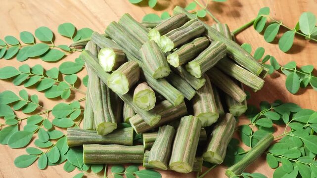 Moringa Oleifera or drumstick vegetable with leaves on wooden
