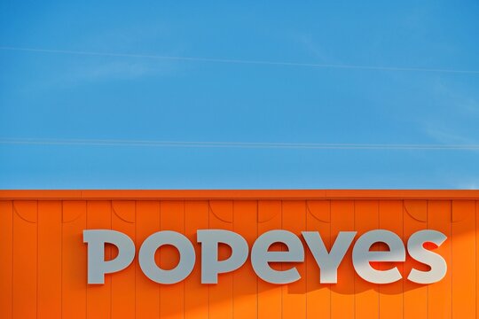 La Nucia, Spain - September 4, 2026: Popeyes logo sign on restaurant building wall. Popeyes Louisiana Kitchen is American multinational chain of fried chicken fast food restaurants