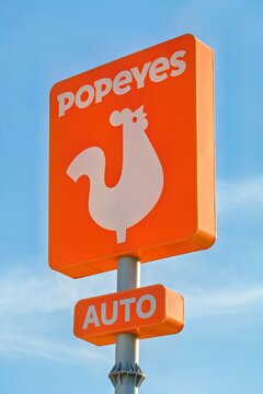 La Nucia, Spain - September 4, 2026: Popeyes logo sign on pole with blue sky background. Popeyes Louisiana Kitchen is American multinational chain of fried chicken fast food restaurants