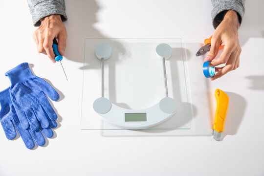 Man repairs of digital weight scale.