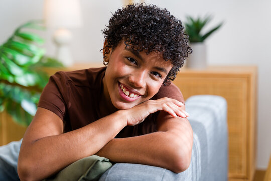 Smiling African American woman leaning on couch armrest