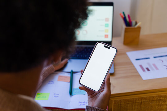 African American person holding mobile phone with blank screen