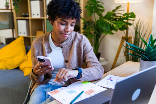 African American woman checking smartwatch and planning