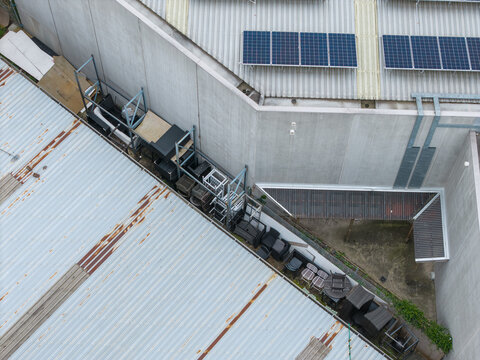 Aerial view of industrial rooftops featuring solar panels and storage racks with outdoor furniture in Bayswater North, Melbourne, Victoria, Australia.