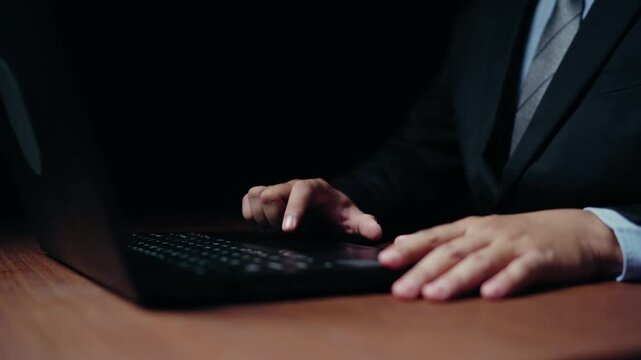 Businessman working on a laptop, close up on hands typing and trackpad usage, professional setting 4k video