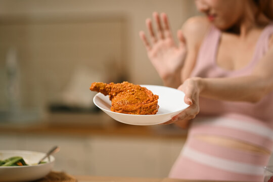 Woman Refusing Fried Chicken on Plate While on Diet, Close Up of Hands Pushing Away Fatty Food