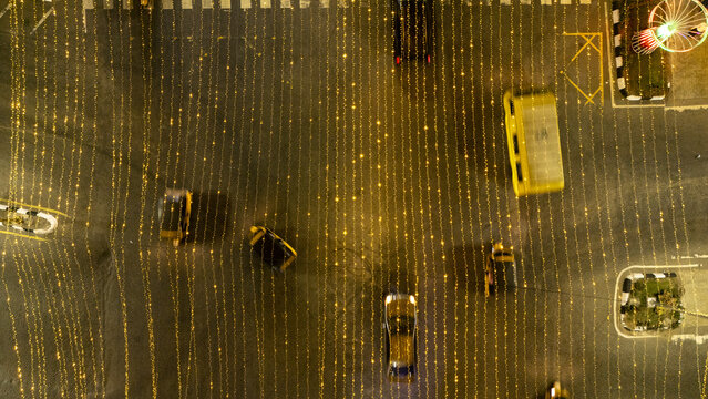 Aerial view of Allen Avenue at night, illuminated by vertical strings of golden festive lights with cars driving along the road in Ikeja, Lagos, Nigeria.