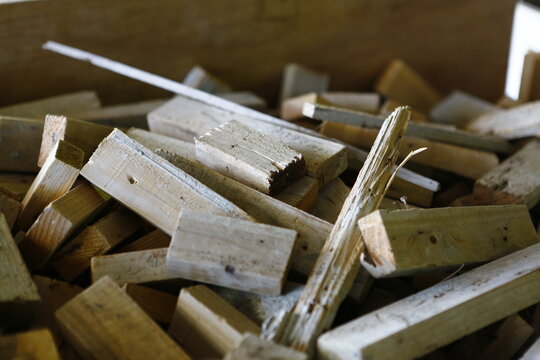 Scattered pieces of cut lumber and wood scraps pile up.