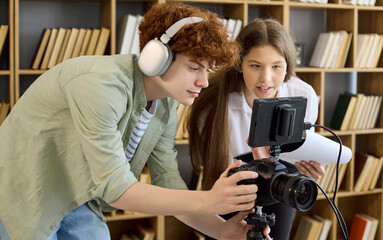 Students filmmakers teamwork in library video production. Young crew sets camera rig, tests audio...
