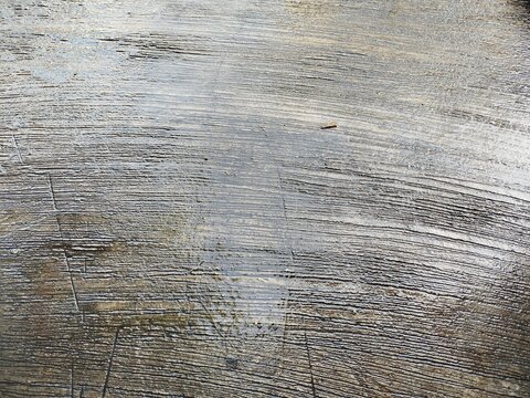 High angle close up photo of a wet rough brushed concrete cement floor surface. Ideal background texture for construction, architecture, and industrial design projects.