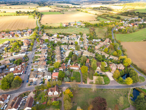 Idyllic drone view of the rural village of Blackmore, Essex, UK as seen from a height. Showing the village green to the bottom and expensive views of arable farmland to the horizon.