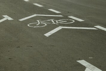 A bike lane sign on a textured asphalt road, perfect for sports themes and daily healthy activities or for environmental topics.  © muhtadi