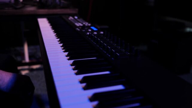 Close-Up of MIDI Keyboard Keys in a Dark Music Studio. Electronic Music Production Equipment Illuminated by Moody Cinematic Lighting.