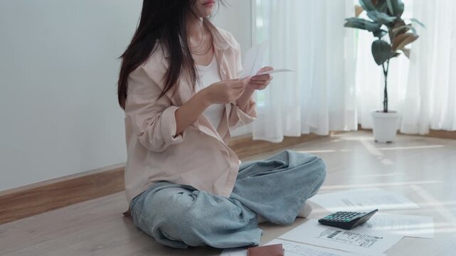 Stressed and headache asian woman with large bills or invoices no money to pay to expenses and credit card debt. shortage, Financial problems, mortgage, loan, bankruptcy, bankrupt, poor, empty wallet