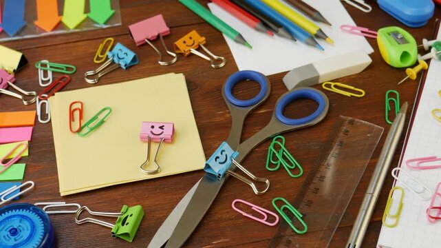 Stationery for creative school desk. Binder clips with smiley faces, correction tape, sticky notes, ruler, scissors, paperclips, rubber eraser, color pencils, sharpener, pen