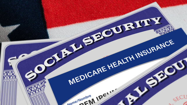Social security benefits card with Medicare Health Insurance card close up on the American flag. Healthcare, retirees, old people, disabled workers concept