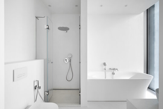 Modern empty bathroom interior mockup with white bathtub, glass shower cabin, and toilet.