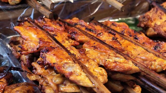 Panning Camera Across Grilled Chicken Wings Skewers Displayed at Asian Night Market