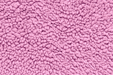 A full-frame, detailed close-up shot of soft pink sherpa fleece fabric, showing a fuzzy, curly teddy bear texture from a top-down view. Concept of warmth, winter comfort, cozy textile © DariaR