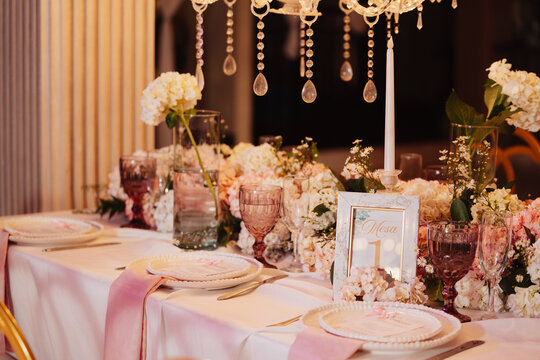 An elegantly decorated table at an event, featuring a floral centerpiece.