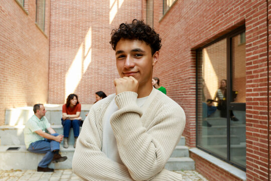 Young Adult Poses  With Others in a Brick Building