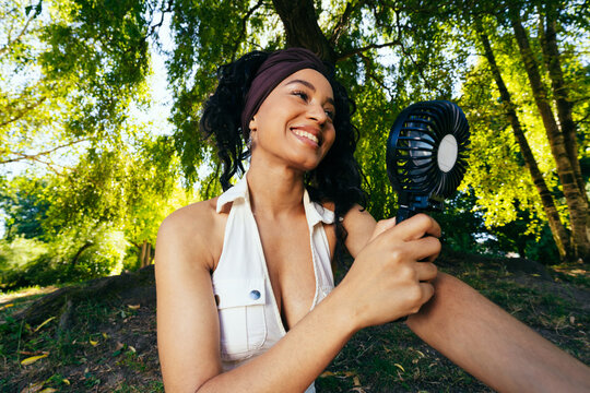 Woman Using Fan in Park
