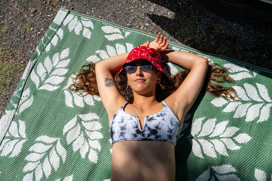 Beautiful brunette sunbathing on a matte