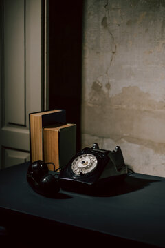 Old Rotary Phone With Books in a Dimly Lit Room