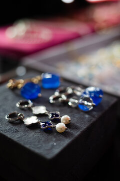Costume jewelry earrings sit on a display tray in a shop. Handmade jewelry.