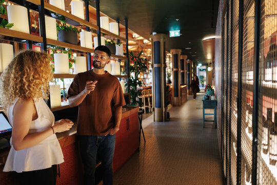Man talking with woman at restaurant reception desk