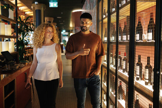 Couple walking in restaurant looking at wine display