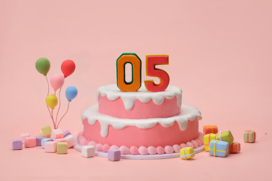 Festive pink birthday cake with number 05 and colorful balloons