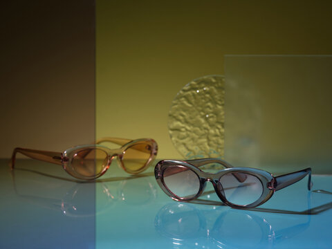 Stylish oval sunglasses displayed on a reflective surface