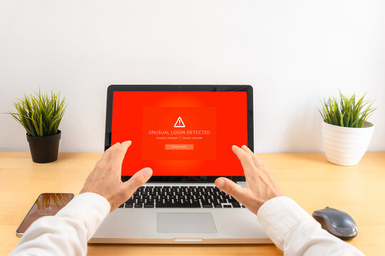 Point of view of laptop user facing an unusual login security alert