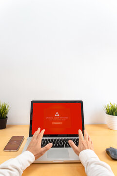 Man using laptop with unusual login detected security warning