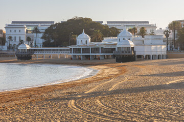 Deserted sandy shoreline of La Caleta beach and the historic Balneario de la Palma building in the quiet early morning, Cadiz, Andalusia, Spain. © nzatravel