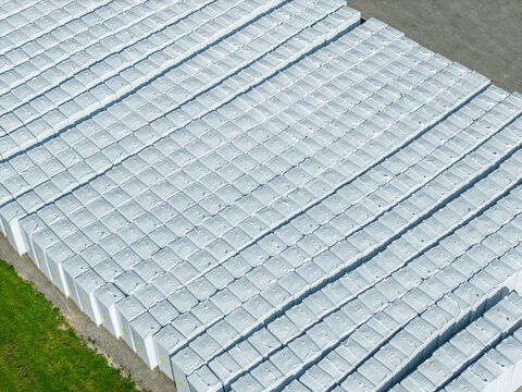 Aerial view of large quantities of compressed peat bales wrapped in white protective packaging and neatly stacked at the B-Peat processing facility in Krimulda Parish, Sigulda Municipality, Latvia.