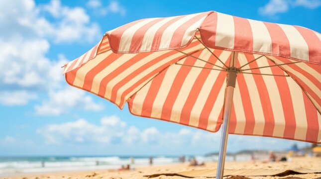 Large Orange and White Striped Beach Umbrella Providing Shade on Sunny Tropical Sandy Beach