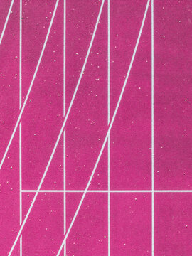 Aerial view of a pink running track with white lane markings and geometric lines in Latvia.