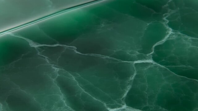 Turquoise ocean wave breaks into white foam across deep water in an overhead view