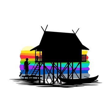 Silhouette of traditional stilt house and fisherman at sunset