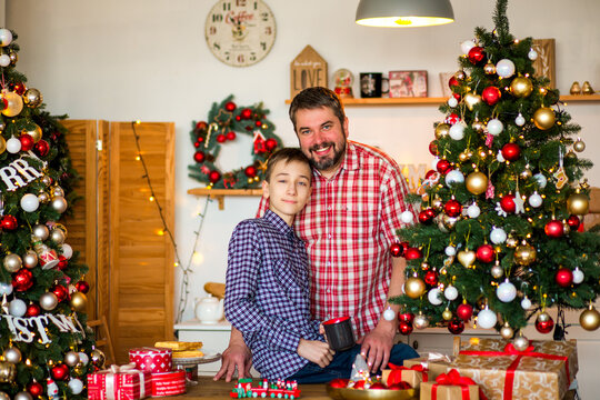 Happy family with a baby celebrating Christmas at home, enjoying cozy holiday moments together near a decorated Christmas tree in a warm festive atmosphere