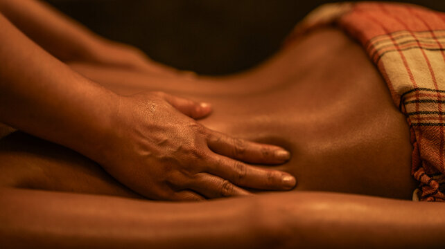 Professional therapist performing a relaxing back massage in a dimly lit wellness spa setting