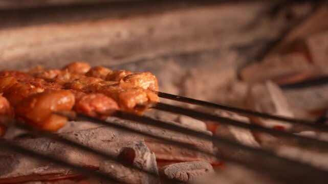 The chef arranging seasoned kebab skewers onto the hot charcoal grill station